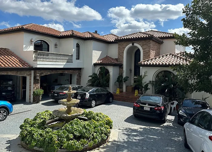A Mediterranean-style luxury estate in Los Angeles used as a rehabilitation center, featuring a cobblestone driveway, fountain, and tiled roof.