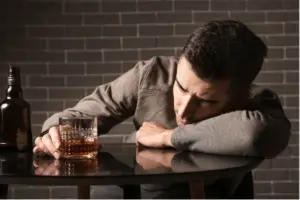 Person experiencing depression and alcohol use at a table