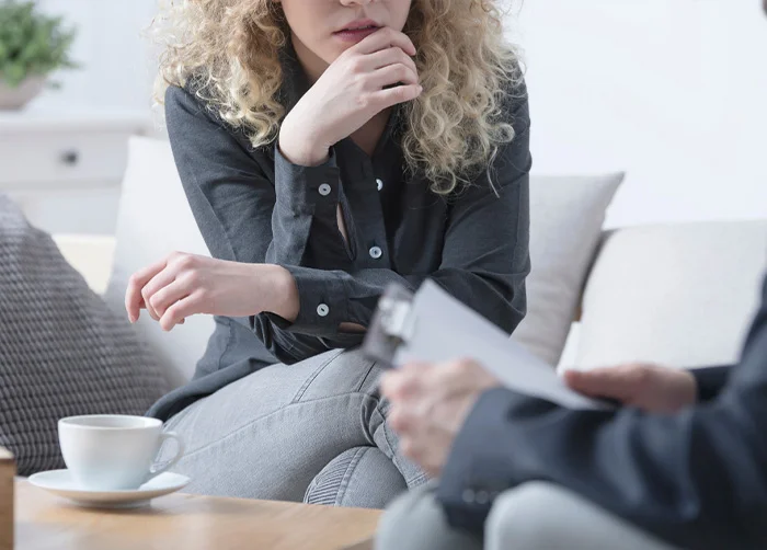 Woman speaking with a treatment professional in a private clinical setting, representing coordinated addiction care from detox and residential treatment through outpatient support and aftercare in Los Angeles.